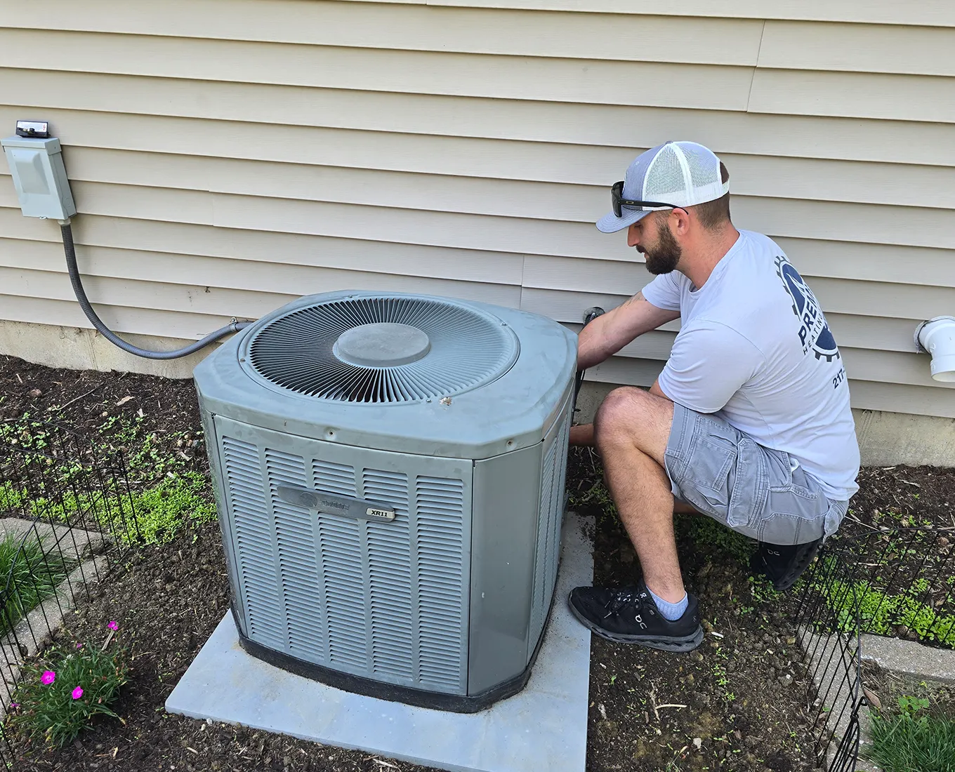 Premier Heating & Air HVAC Technician installing new air conditioner in springfield il