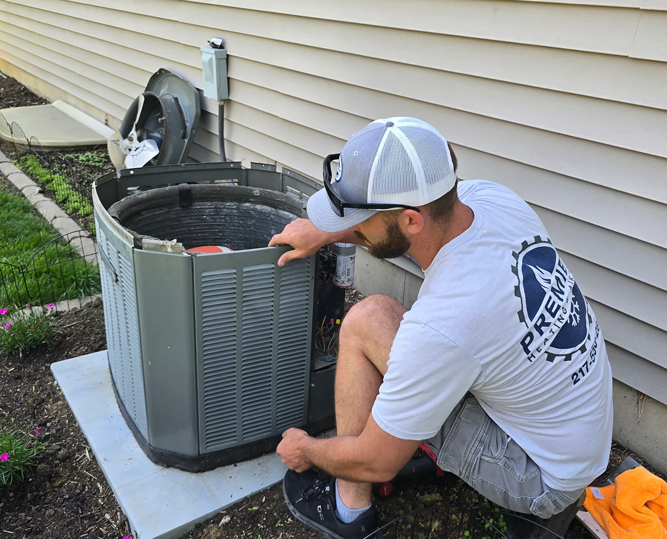 Premier Heating & Air HVAC Technician repairing air conditioning unit in springfield il