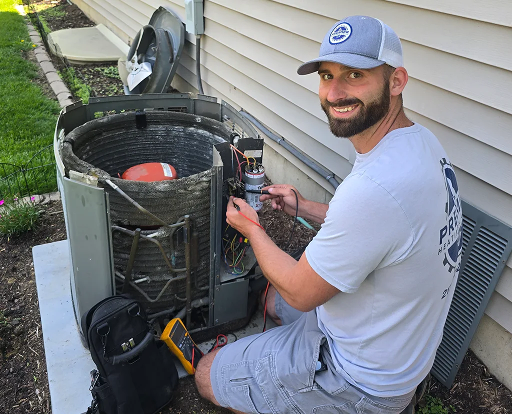 Premier Heating & Air HVAC Technician working on an air conditioner in springfield il