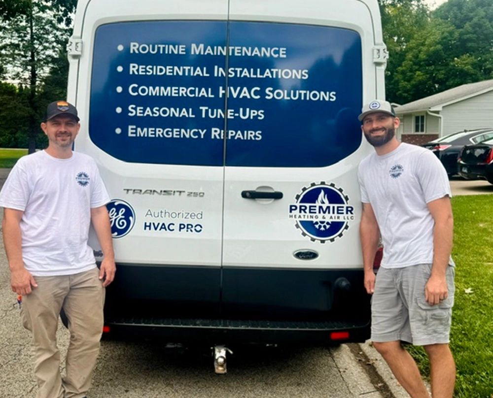 premier heating & air standing outside in front of a company service van.